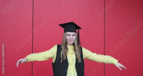 Young beautiful blond female in graduation cap with emotional facial expression on red background. Happy to finish school, college or university video footage 4k