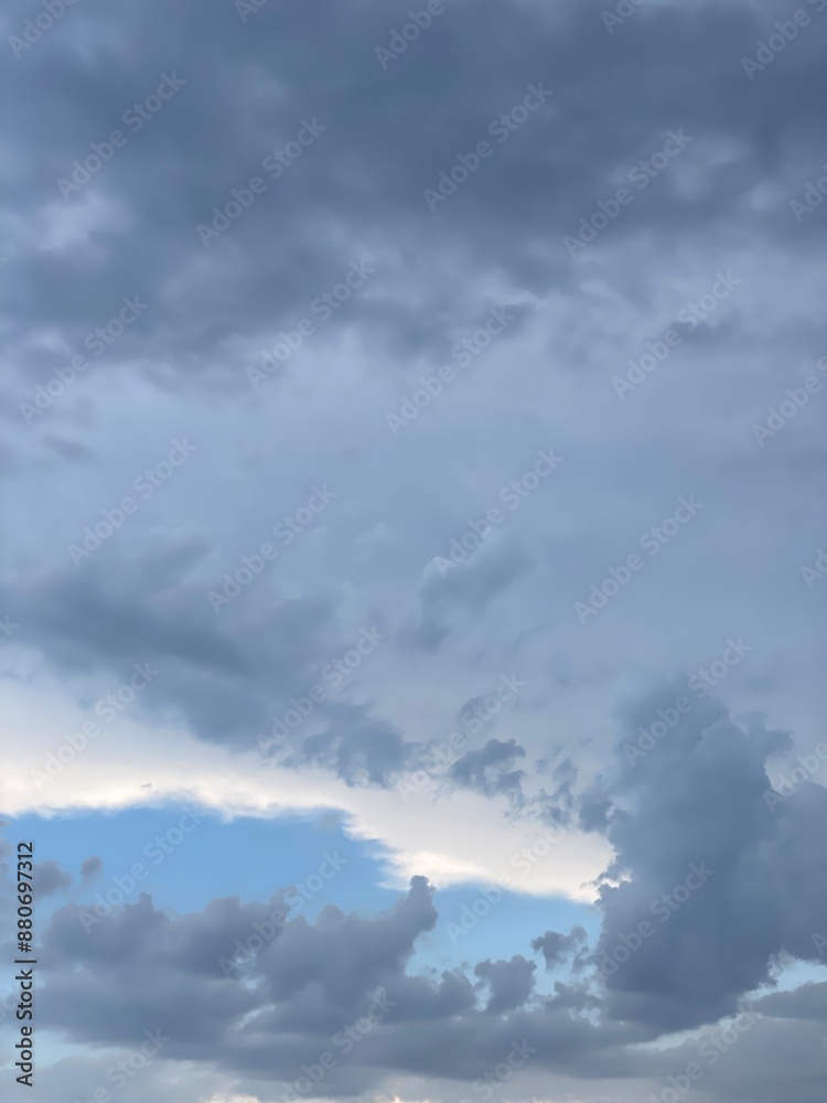 Blue, cloudy, moody sky. The sun is breaking through the cloud Blue, cloudy, moody sky. The sun is breaking through the cloud