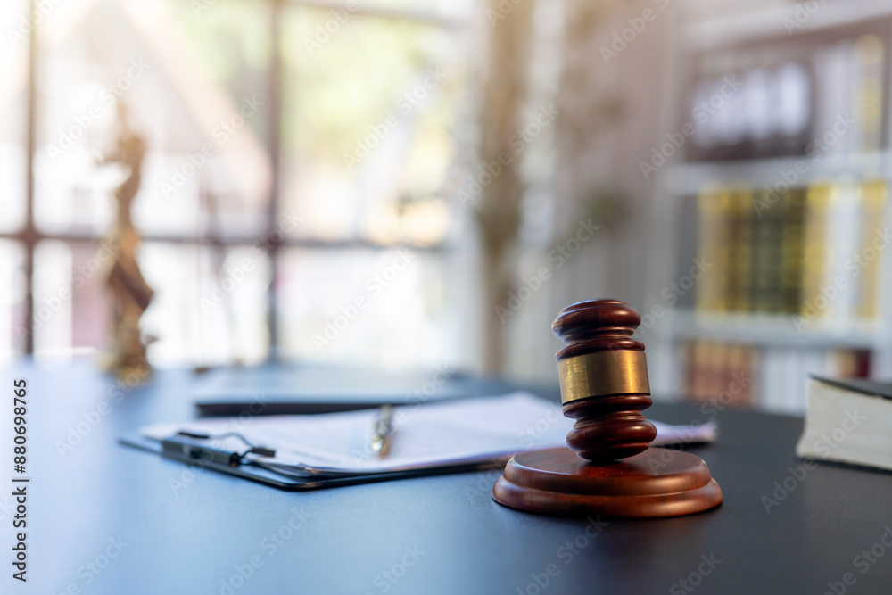 A wooden gavel sits on a desk next to a stack of books A wooden gavel sits on a desk next to a stack of books