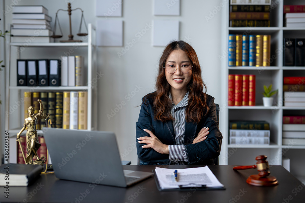A woman is sitting at a desk with a laptop and a stack of papers A woman is sitting at a desk with a laptop and a stack of papers
