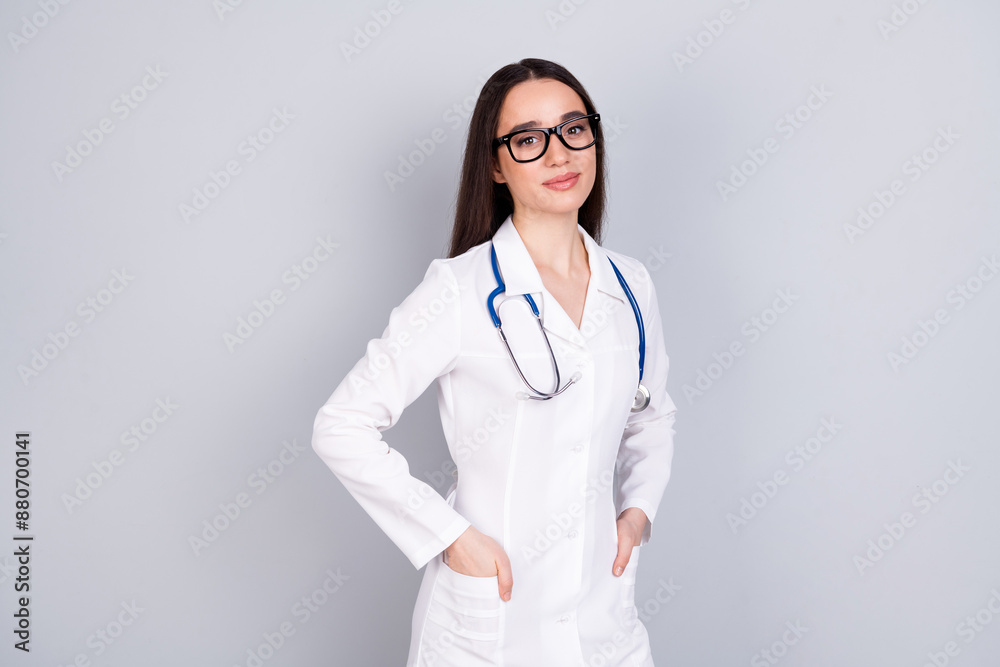 Photo of charming adorable woman surgeon wear white doctor uniform hand in pockets isolated on grey color background Photo of charming adorable woman surgeon wear white doctor uniform hand in pockets isolated on grey color background