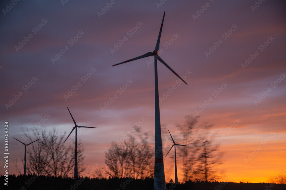 Obraz premium Windräder im Abendrot vor dramatischem Sonnenuntergang