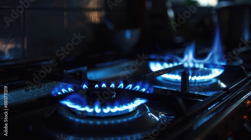 Gas stove with blue flame in dark kitchen black background copy space focus on fuel