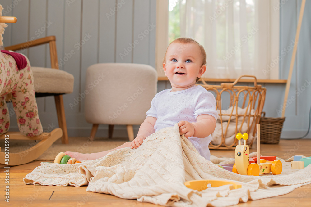 Happy cute baby playing with children's toys at home, sitting on the floor in the living room. Happy cute baby playing with children's toys at home, sitting on the floor in the living room.