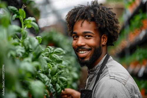 Happy young man working in greenhouse