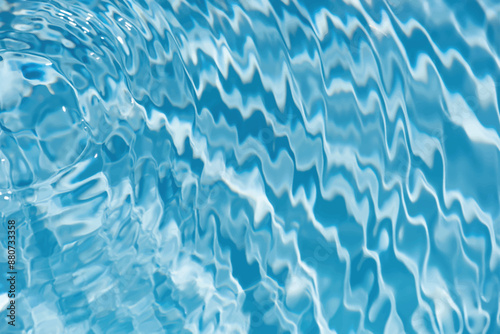 Blue water with ripples on the surface. Defocus blurred transparent blue colored clear calm water surface texture with splashes and bubbles. Water waves with shining pattern texture background.