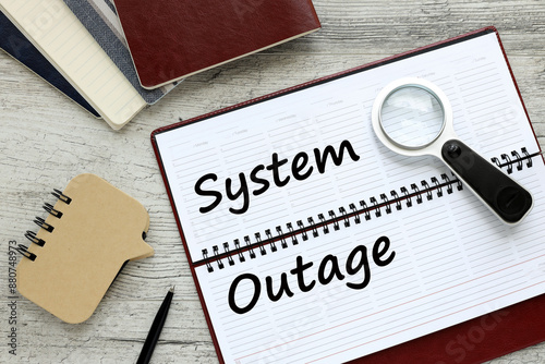 System Outage text on a white page of a diary on the table
