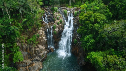 Aerial View of a Cascading Waterfall in a Lush Green Forest.