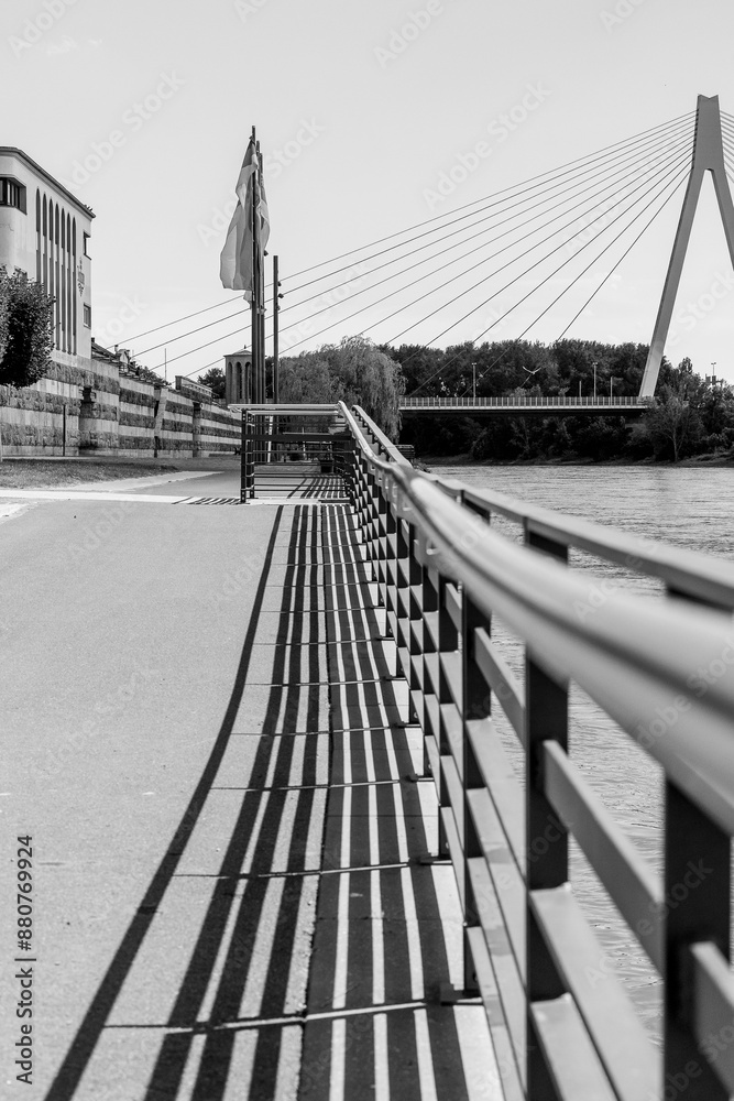 Obraz premium Rheinpromenade Neuwied mit Geländer und Pegelturm und Fahnen Schwarz-Weiß