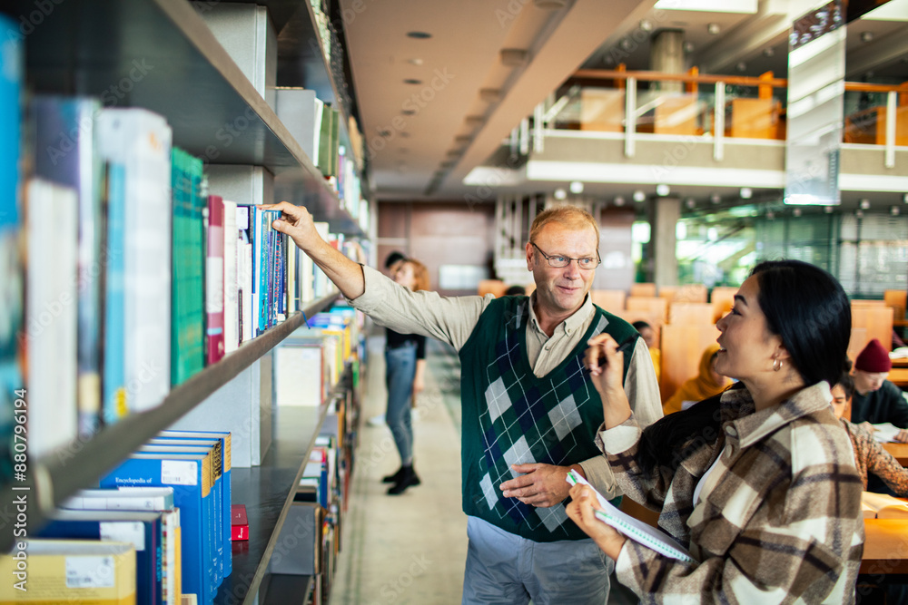 Professor helping student in university library Professor helping student in university library