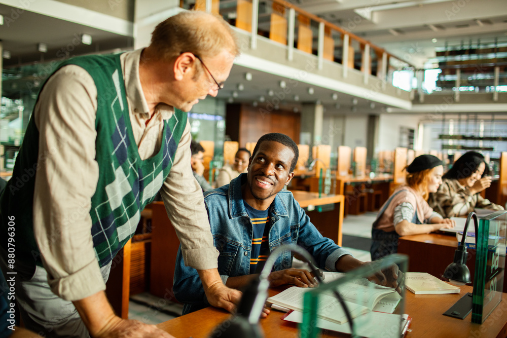 Professor helping student in university library Professor helping student in university library