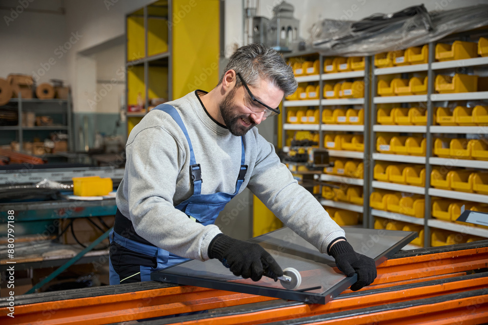 Middle-aged man at a workplace in window production Middle-aged man at a workplace in window production