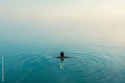 woman swimming and floating in lake water, practicing meditation and breathing exercise, integration of mind and body at sunset in beautiful natural scenery