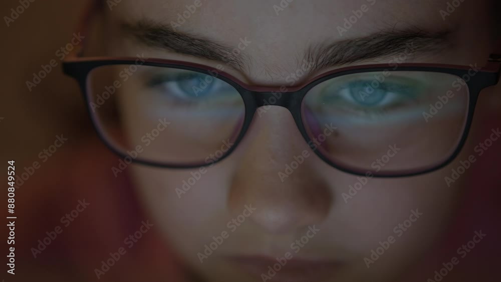 Face Girl is Looking at Digital Tablet Computer Screen With Glasses. Child Eyes Staring at Device Screen Watching on Social Media. Girl in Eye Glasses With Reflections Using Digital Tablet PC at Night