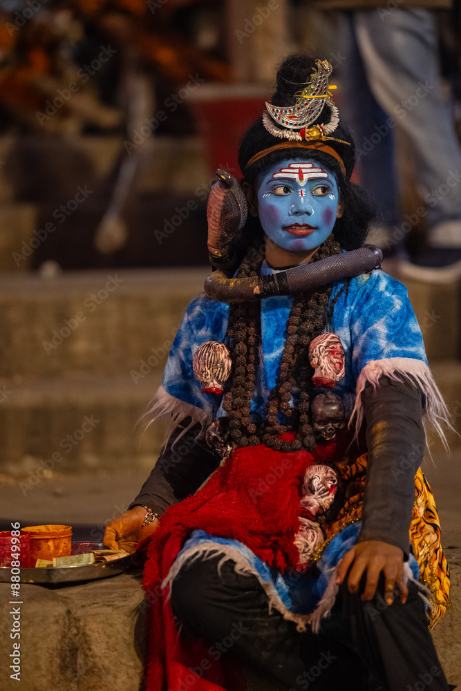 Portrait of a young boy dress up like lord shiva with painted blue face at dashashwamedh ghat near river ganges in varanasi city Portrait of a young boy dress up like lord shiva with painted blue face at dashashwamedh ghat near river ganges in varanasi city
