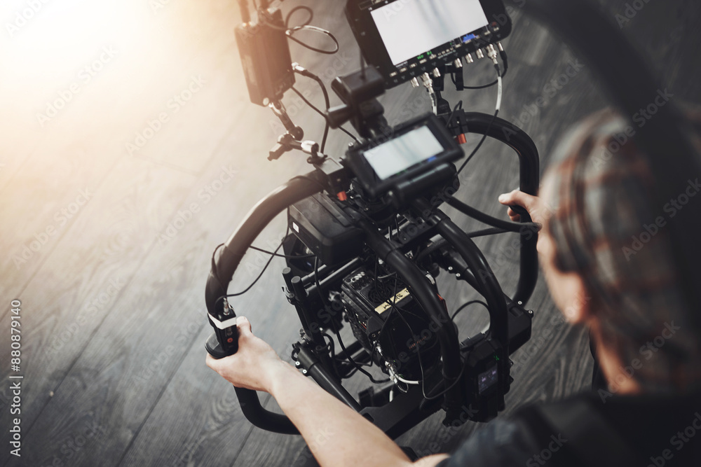 Fototapeta premium Videographer, camera and man filming in studio for photography, production and media. Behind the scenes, backstage and person with stabilizing equipment on set shooting videos, documentary or film
