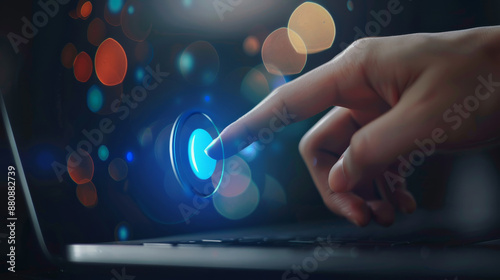 Hand reaching out towards a glowing blue touch button against a backdrop of colorful bokeh, representing interactivity and modern technology. photo