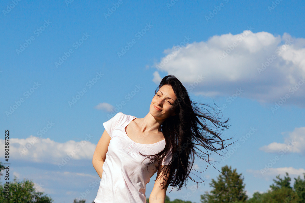 beautiful brunette stands in the wind on a summer day beautiful brunette stands in the wind on a summer day