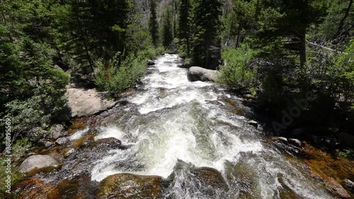 river rapids flow swiftly down the rocky mountains with the help of snow melt