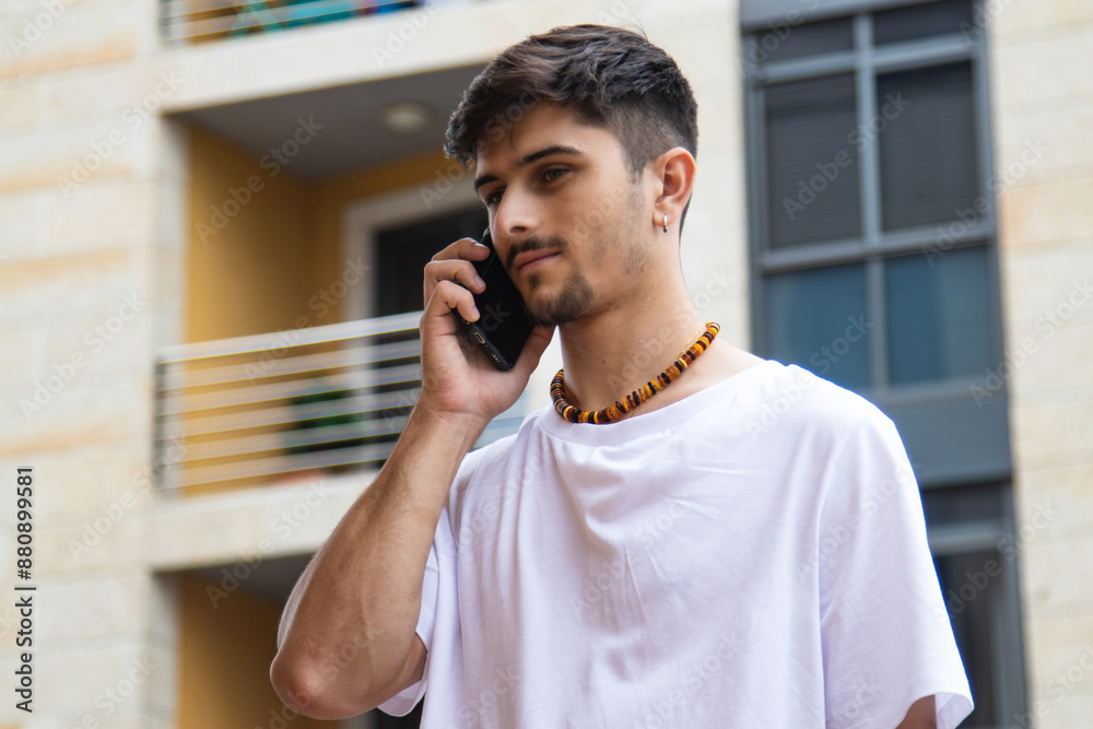 modern young man talking with the smartphone on the street modern young man talking with the smartphone on the street