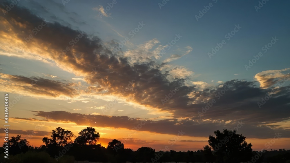 A serene sunset with dramatic cloud formations and a glowing orange and yellow sky, creating a peaceful and scenic end to an evening in nature A serene sunset with dramatic cloud formations and a glowing orange and yellow sky, creating a peaceful and scenic end to an evening in nature