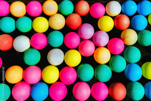 Top view of many colorful plastic balls on water. View of colored sponge balls. Many colorful balls as background. Lots of colorful balls for children to play in the water park. Toy pool for kids.