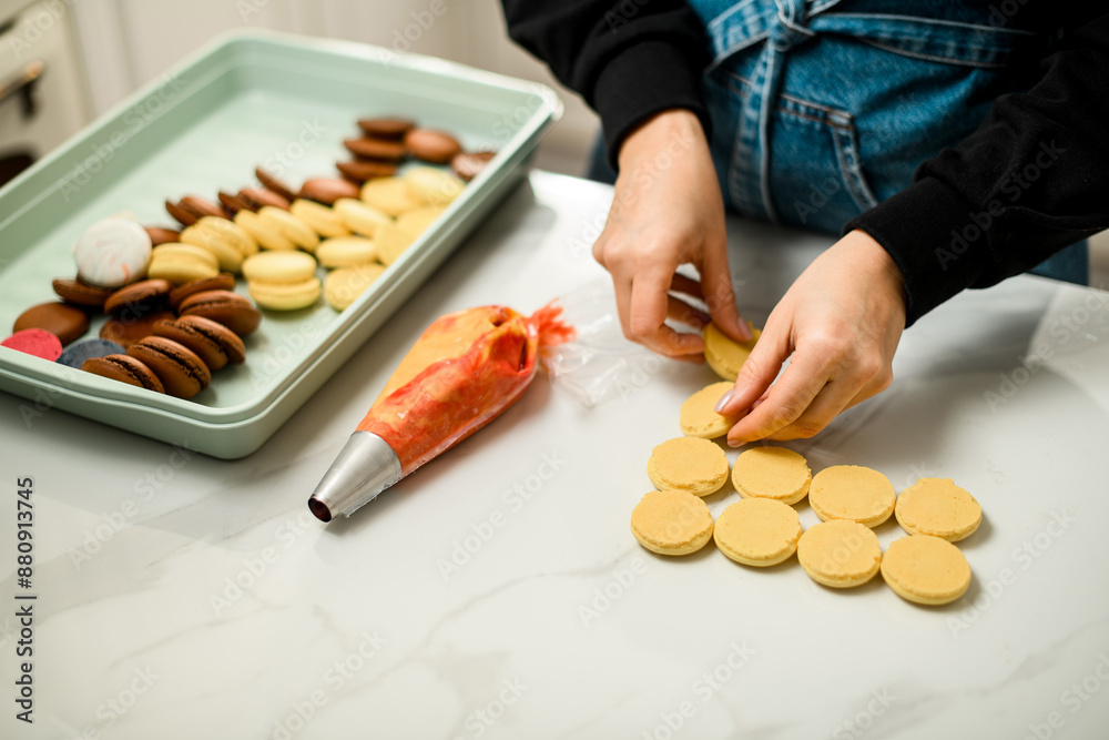 Multi-colored macaron preparations in a big plastic bowl on a white marble table Multi-colored macaron preparations in a big plastic bowl on a white marble table