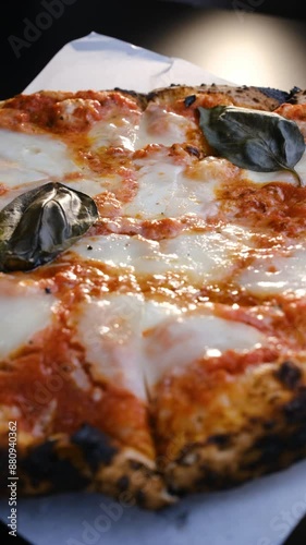 Close-up, Margherita pizza with melted mozzarella cheese spinning in a circle. Vertical video. Fresh delicious food. Pizza Margherita. Italian Cuisine.