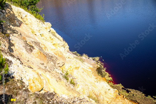 Contrast between the rocky wall with mineral residues and the blue water, Solfatara area, Pomezia, Rome, Italy photo