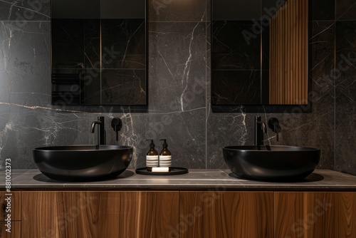 Close up of double black sink with mirrors standing in on dark marble wall