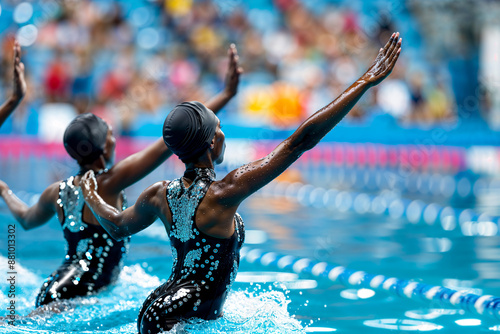 Synchronized swimming team performing in indoor pool