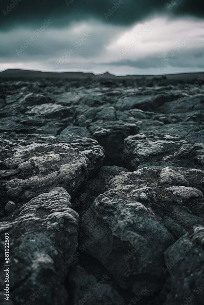 Obraz premium Desolate Rocky Terrain Under Ominous Cloudy Sky