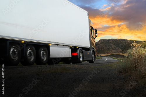 Truck LKW lastwagen or lorry van with trailer of a forwarding agent company drives on the highway rural road at sunset. Fast transportation, delivery and logistics. Shipping container transport.