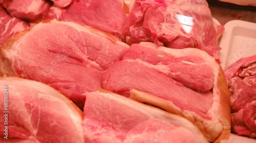 Refrigerator in a store, a pile of raw meat goods in a butcher shop. Meat department for sale with raw fresh meat, close-up.