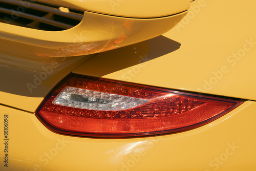 vintage classic retro car bright yellow color back view on glass part and headlight