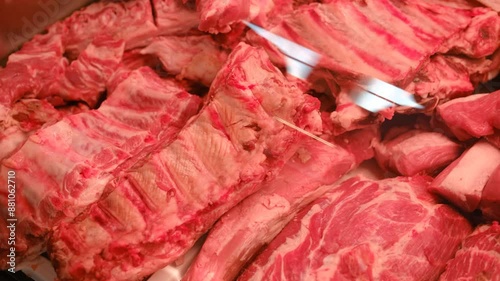 Refrigerator in a store, a pile of raw meat goods in a butcher shop. Meat department for sale with raw fresh meat, close-up.