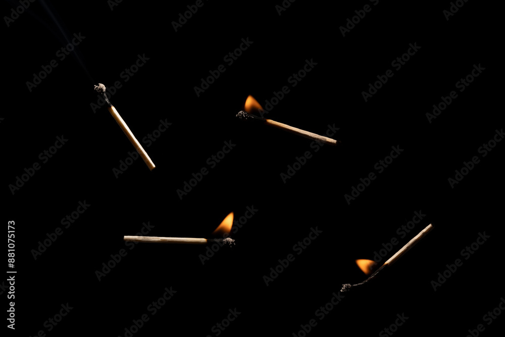 Lit falling match on a black background.
