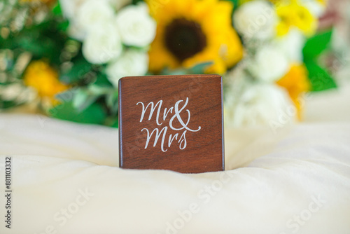 фотографія Wood block with white text that readsmr&Mrs, on white surface with yellow flowe