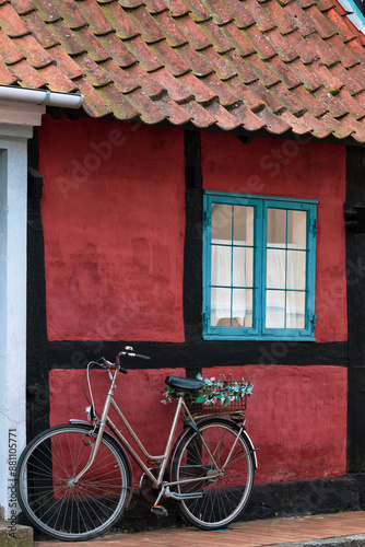 Bike parked in front of  dark red half-timbered house on the island Bornholm, Denmark.