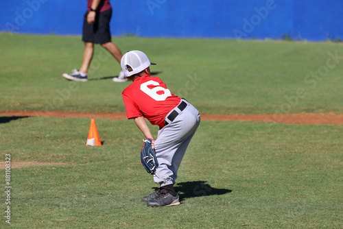 A 5 year old ball player watching the ball on the field.