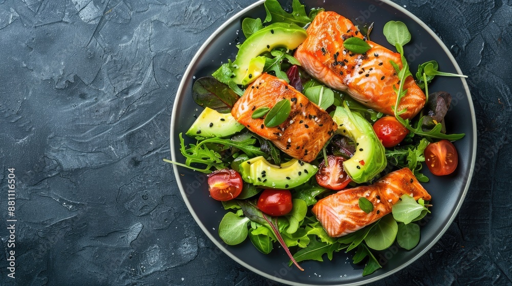 Top view of salmon salad with avocado tomato and greens on dark background Top view of salmon salad with avocado tomato and greens on dark background