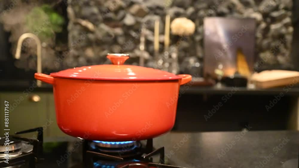 Linda panela vermelha no fogão cozinhando, com vapor saindo pela borda fazendo o jantar em casa fazendo pinhão cozido