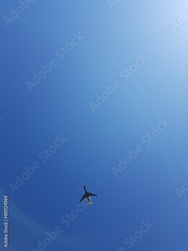 Airplane flying in the blue sky in the sunny day in summer