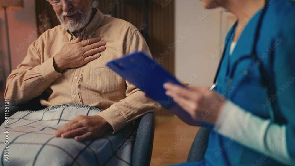 Woman doctor visiting sick senior man at a retirement home, talking with patient