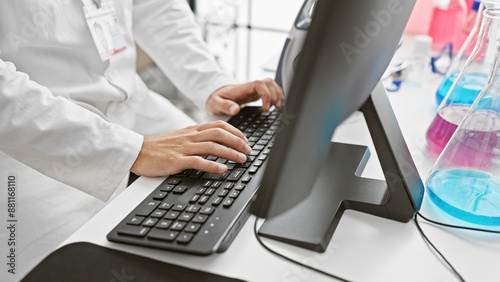 A healthcare professional works on a computer in a modern hospital lab, handling research data.