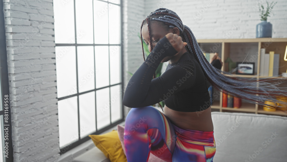 African american woman with braids in activewear posing indoors against ...