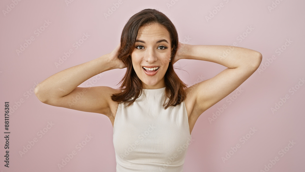 A young, attractive hispanic woman poses with a joyful expression, isolated on a pink background. A young, attractive hispanic woman poses with a joyful expression, isolated on a pink background.