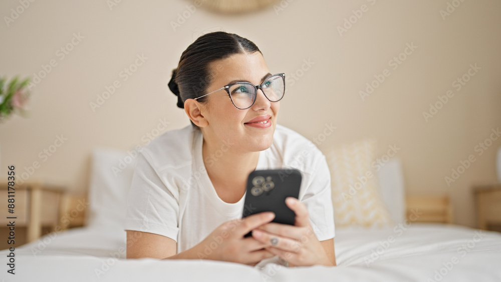 Young beautiful hispanic woman lying on bed smiling at bedroom Young beautiful hispanic woman lying on bed smiling at bedroom