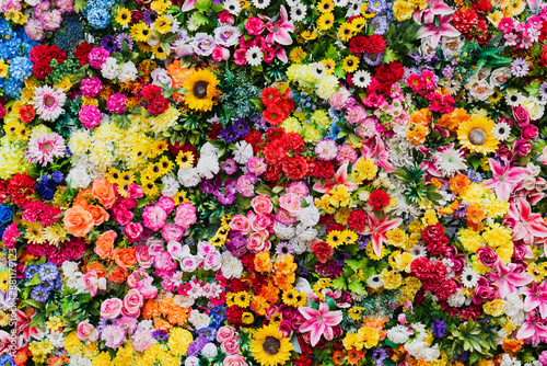 Photo background texture, wall made of various artificial flowers.