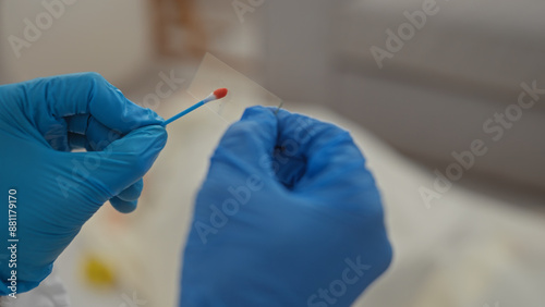A person in gloves examines evidence during an indoor investigation at a crime scene. photo